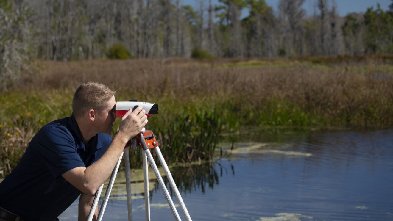 Person surveying a surface water.